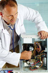 Man examining computer with stethoscope