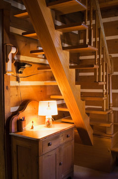 Antique Wooden Cabinet Below Uneven Wooden Stairs In Canadiana Cottage-style Log Home, Quebec, Canada