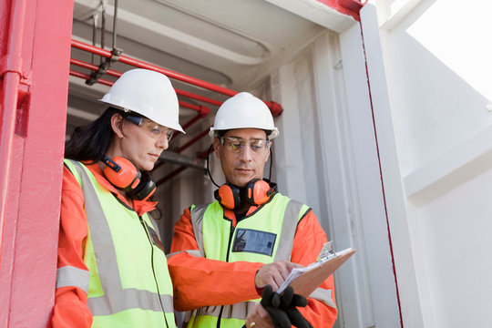 Workers discussing document at construction site