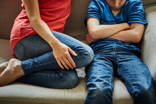 Mother on sofa scolding son