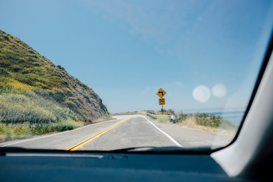 Car windscreen view of winding coast road, Big Sur, California, USA