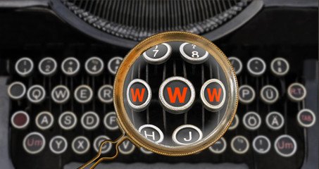 Anachronismus WWW auf  Tastatur einer antiken Schreibmaschine  gefunden mit einer Lupe –...