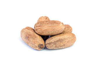 Nutmeg on wooden spoon over white background.