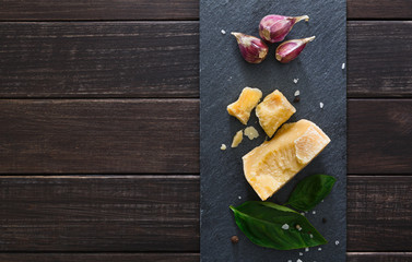 Cheese delikatessen with copy space on black stone, parmesan