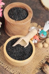 Poppy seeds of organic on wood background.