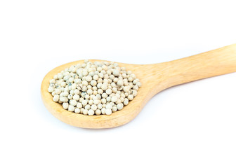 White pepper on wooden spoon over white background