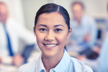 group of smiling businesspeople meeting in office