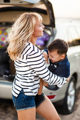 Beautiful woman with a child of four years in the car are going to have a trip