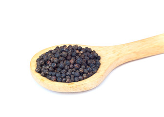 Black pepper on wooden spoon over white background