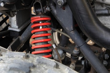 Red coil spring stands out among quad bike suspension parts