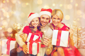Fototapeta na wymiar smiling family holding gift boxes and sparkles
