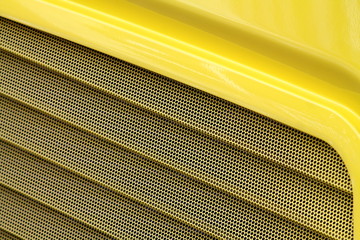 Macro of yellow lack surface of a bus with ventilation. 