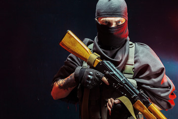 Portrait of man with rifle against black  background