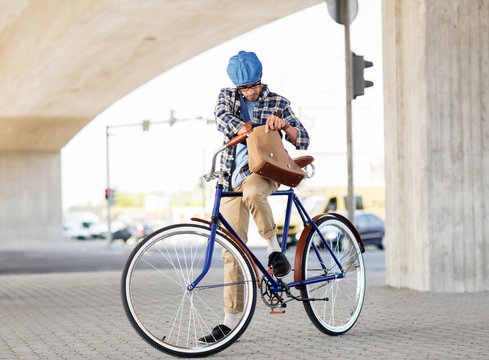 hipster man with shoulder bag on fixed gear bike