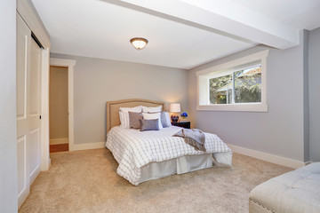 Adorable bedroom interior with nice bedding and many pillows. Also carpet floor.