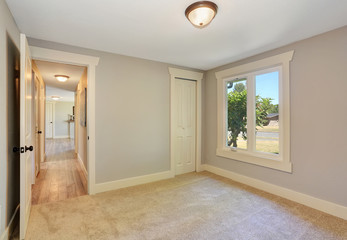 Empty room interior with carpet floor. Open door to the hallway