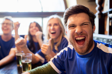 football fans or friends with beer at sport bar