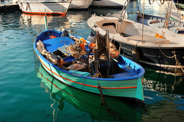 Fototapeta na wymiar Fishing boat with some gear inside moored in the port