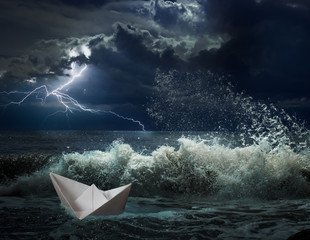 paper boat in ocean storm with lgihting and waves