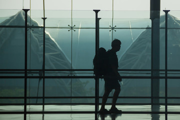 Silhouette of Travellers backpack into an Airport