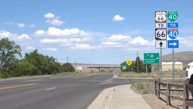 Road signs on route 66, road traffic only on the narrow part of the road in the distance near horizon