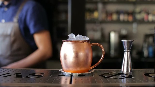 Barman is decorated with a cocktail in a copper bowl
