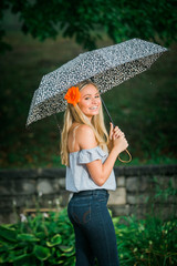High school senior poses with umbrella for portraits on a rainy