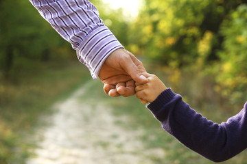 the parent holds the hand of a small child
