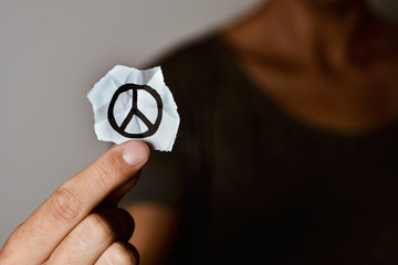 man with a peace symbol in a piece of paper