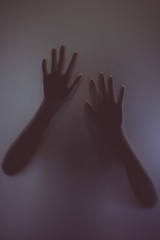 The silhouette of the hand on sand glass - obrazy, fototapety, plakaty