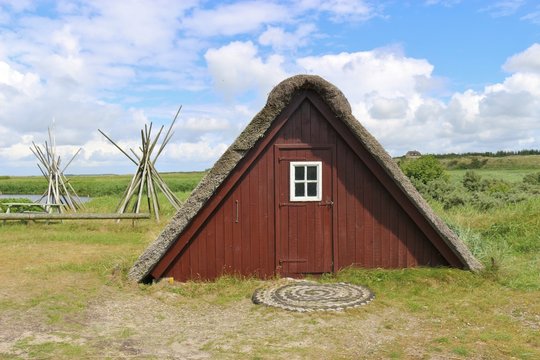 Old fisher hut with thatched roof in Denmark, Europe. In the town Nymindegab, next to west coast and the Ringkobing Fjord.