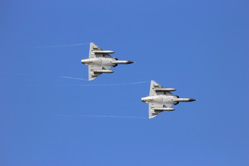 Two fighters jet in formation on a blue sky