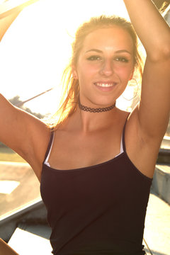 Sch&ouml;ne junge Frau mit sexy Tr&auml;gertop im sommerlichen Gegenlicht &ndash; Portrait