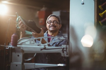 Shoemaker examining a shoe