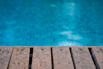 Wooden deck of the swimming pool with rain drops, ideal for back