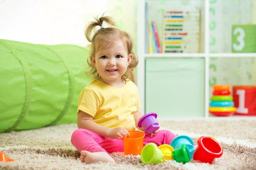 Cheerful kid playing in nursery room