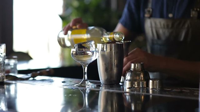 Hands of the barman add alcohol cocktail