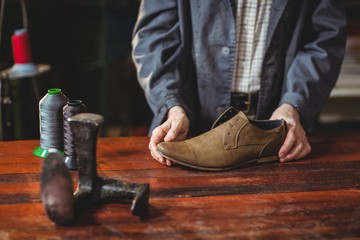 Shoemaker examining a shoe