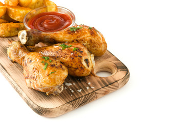 Roast chicken drumsticks and chips on cutting board isolated on white background
