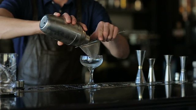 Hands of the bartender mixing an alcoholic cocktail