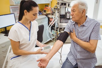 Obraz premium Female doctor checking blood pressure of patient