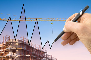 Hand draws a graph with a background of a construction site 