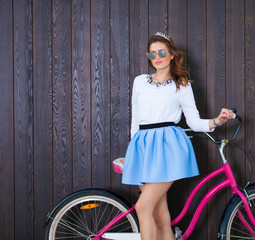 Fototapeta na wymiar Trendy Fashionable Girl with Vintage Bike on Wooden Background. Toned Photo. Modern Youth Lifestyle Concept. Close up.