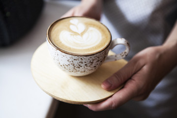 female hands holding Latte art, coffee cup.