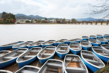 Rowing boats (blue and white) at rental boat in Hozu-gawa River,Arashiyama,Kyoto. In raining day