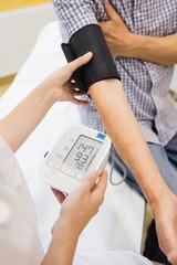 Female doctor checking blood pressure of patient