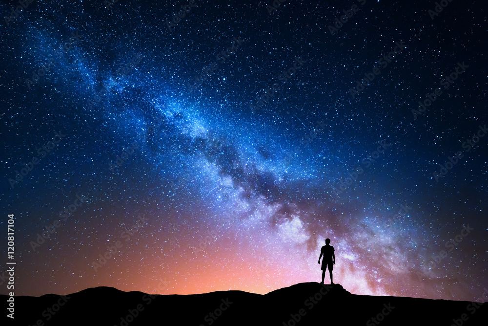 Wall mural milky way. beautiful night sky with stars and silhouette of a standing alone man on the mountain. mi