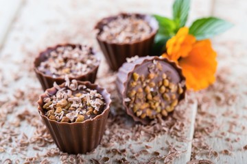 Four chocolate cupcakes on white board with flowers