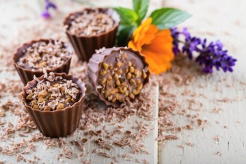Several chocolate cupcakes on white board with flowers