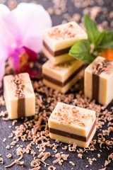 Several nougat cubes on slate stone with orchid bloom